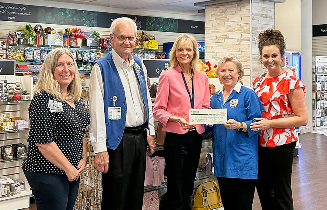 Kim Schuler, Cloverkey's Chief Revenue Officer, presents a check to volunteers at the Texas Health Huguley Hospital gift shop